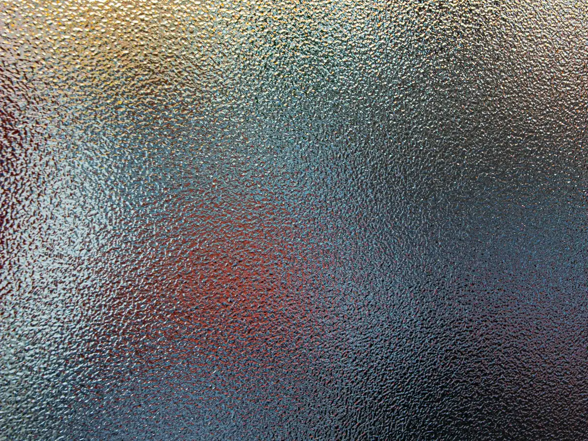 Verre texturé clair traversé par une lumière chaude